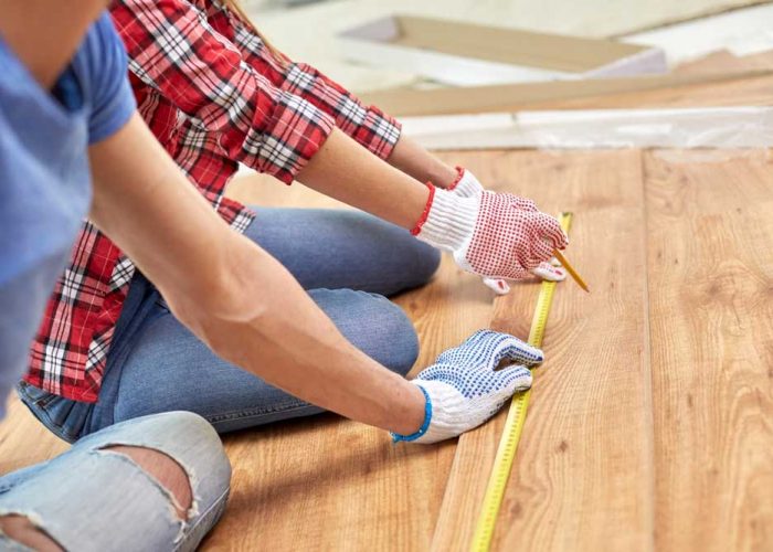 repair-building-flooring-people-concept-close-up-couple-hands-with-ruler-measuring-parquet-board-homeמוקטן